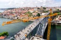 Porto, Portugal - 24 June 2019: D. Luis Bridge in Porto with the subway passing, yellow crane works in the reconstruction of