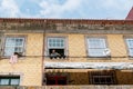 Local woman hangs clothing on a clothesline to dry on a window, facade typical of Portugal