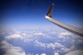 White fluffy clouds in the blue sky under the wing of the aircraft of the airline Ryanair.