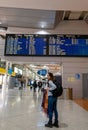 Porto, Portugal: November 13 2022. Young woman standing with her backpack looks at schedule on airport station. Themed public