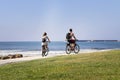 Couple young people riding a bike by the ocean