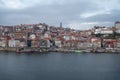 Porto, Portugal, October 31,2020. View on colorful old houses on hill in old part of city and embankment of Douro river in rainy