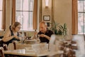 Some visitors having breakfast inside retro style restaurant with wooden furniture Royalty Free Stock Photo