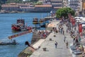 View of Ribeira docks on Porto downtown, with tourist people, recreational boats, Douro river and buildings