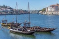 View of river Douro, with tourists, Rabelo boats on docks, transport for Porto Wine, Porto city as background Royalty Free Stock Photo