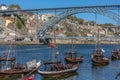 View of river Douro, with tourists, Rabelo boats on docks, transport for Porto Wine, D. Luis bridge and Porto city as background Royalty Free Stock Photo