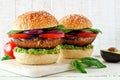 Portobello mushroom meatless burgers on a marble serving board against a white wood background Royalty Free Stock Photo