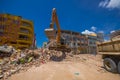 Portoviejo, Ecuador - April, 18, 2016: Heavy machinery picking rubble from destroyed buildings after tragic and