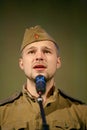 Portra Soviet soldier, poet, hero in uniform of World War II playing the accordion over black background.