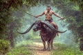 A portrai thai warrior in Ayutthaya costume he have dual swords and riding the long horn buffalo