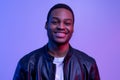 Portraif Of Happy Black Guy Posing In Leather Jacket Under Neon Light