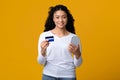 Portraif of smiling beautiful black woman with smartphone and credit card