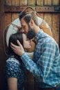 portrair man affectionately kissing woman on wooden wall backgro