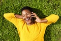 Above of happy young black woman lying on green grass and talking with mobile phone Royalty Free Stock Photo