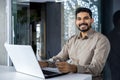 Portrait of accountant financier at workplace, businessman with laptop smiling and looking at camera inside office at Royalty Free Stock Photo
