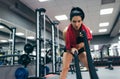 Portrait of active brunette sportswoman working out in functional training gym doing crossfit exercise with battle ropes with red Royalty Free Stock Photo