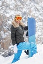 Portrait of active female snowboarder standing on top of the mountain background Royalty Free Stock Photo