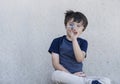 Portrait active little boy playing with toy airplane against gray concrete background, Child throwing foam airplane, Kid playing