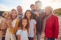 Portrait Of Active Multi-Generation Family On Winter Beach Vacation Resting By Gate Royalty Free Stock Photo