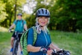 Portrait of active senior couple riding bicycles at summer park, woman is looking at camera, healthy lifestyle concept. Royalty Free Stock Photo