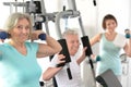 Active smiling people exercising in gym