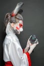 Portrait of actress with makeup and costume holding bird on black background Royalty Free Stock Photo