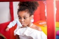 Portrait of adorable African American girl kid with curly hair eating sweet candy, joyful child enjoy with her snack Royalty Free Stock Photo