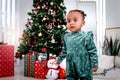 Portrait of adorable African American little girl child standing in living room with many gift boxes presents under Christmas tree Royalty Free Stock Photo