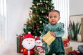 Portrait of adorable African American little girl child standing in living room with many gift boxes presents under Christmas tree Royalty Free Stock Photo