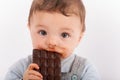 Portrait of an adorable baby boy eating a plate of chocolate. Royalty Free Stock Photo