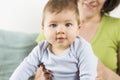 Portrait of adorable baby boy sitting in his mother arms. Royalty Free Stock Photo