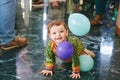 adorable baby crawling across the floor at the party, playing with balloons Royalty Free Stock Photo