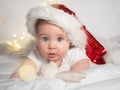 Adorable baby girl in Santa hat lying on the bed Royalty Free Stock Photo