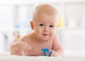 Portrait of adorable baby. Kid boy lying on his stomach and holding teether toy. Royalty Free Stock Photo