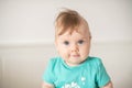 Portrait of adorable Caucasian baby girl with blue eyes, looking at the camera calmly, with curiosity