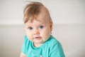 Portrait of adorable Caucasian baby girl with blue eyes, looking at the camera calmly, with curiosity