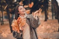 Portrait of adorable cheerful lady arm hold catch flying maple leaf toothy smile good mood free time outside