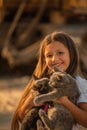 Portrait of adorable child with kitten. Baby girl holding hands a kitten in the light of sunset, pet, friend, lifestyle Royalty Free Stock Photo