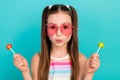 Portrait of adorable girl pouted lips hands hold lollipop candy stick isolated on bright turquoise color background Royalty Free Stock Photo