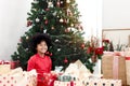 Portrait of adorable happy smiling African American girl child with black curry hair holding Christmas present gift box under Royalty Free Stock Photo