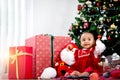 Portrait of adorable happy smiling African American little girl child sitting with many gift boxes presents under Christmas tree Royalty Free Stock Photo