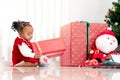 Portrait of adorable happy smiling African American little girl child sitting with many gift boxes presents under Christmas tree Royalty Free Stock Photo