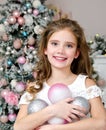 Portrait of adorable happy smiling little girl child in princess dress holding christmas balls Royalty Free Stock Photo