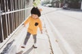 Portrait of adorable Japanese toddler walking explore morning sun chasing her own shadow, having healthy morning walk can absorb