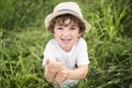 Portrait of adorable kid boy with hat standing on a summer meadow Royalty Free Stock Photo