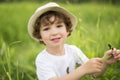 Portrait of adorable kid boy with hat standing on a summer meadow Royalty Free Stock Photo