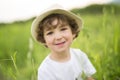 Portrait of adorable kid boy with hat standing on a summer meadow Royalty Free Stock Photo