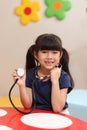 Portrait of adorable kid pretending to be doctor, Asian girl with long hair playing funny and holding doctor stethoscope