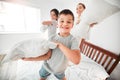 Portrait of adorable little boy, sister and mother having a fun pillow fight at home. Happy young family with mother and Royalty Free Stock Photo