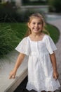 Portrait of adorable little girl in beautiful white summer dress. Five year old girl smile Royalty Free Stock Photo